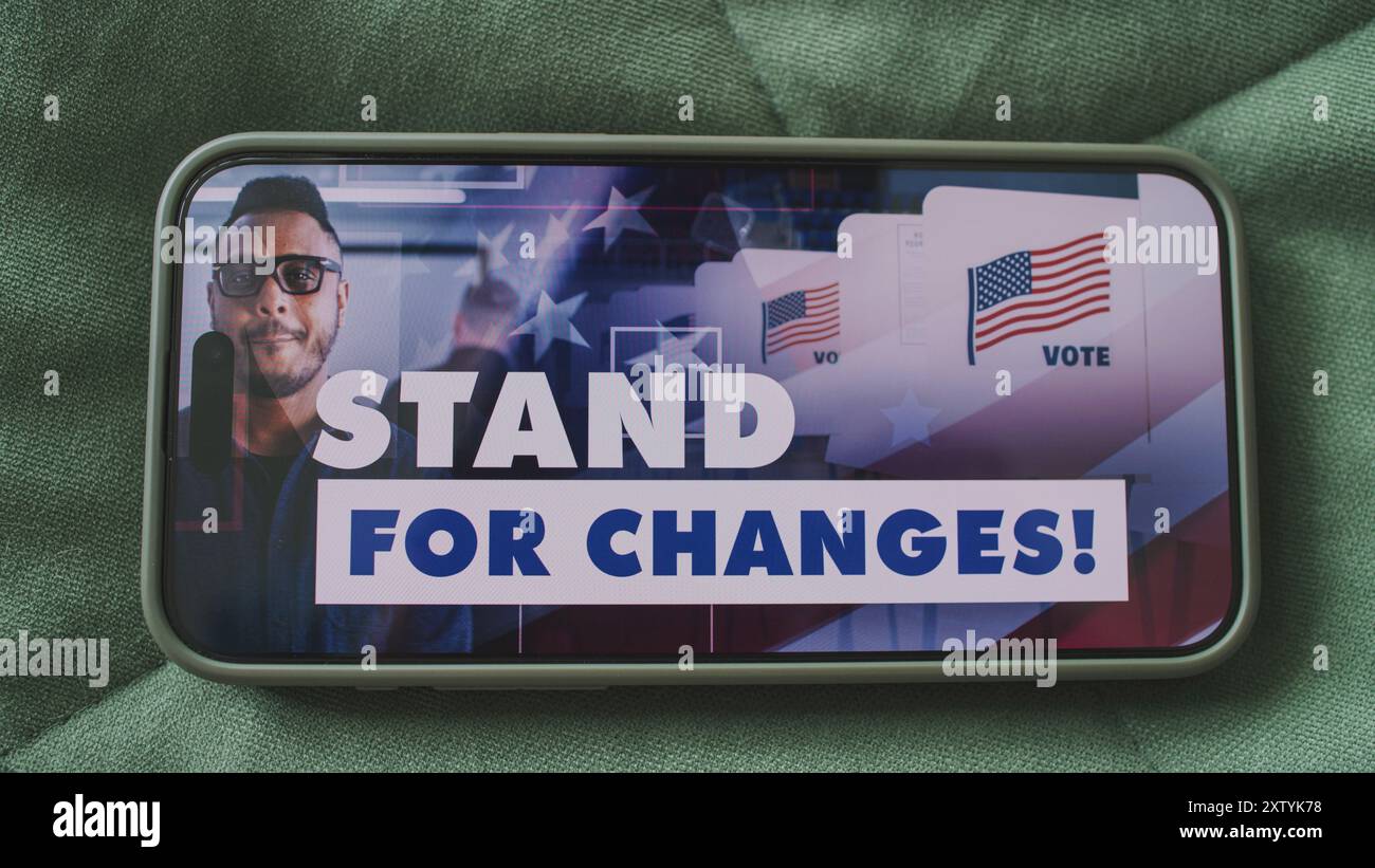 Smartphone screen with displayed US presidential elections political campaign. Multiethnic voters call to vote in social advertising. National Election Day in the United States. Handheld. Close Up. Stock Photo