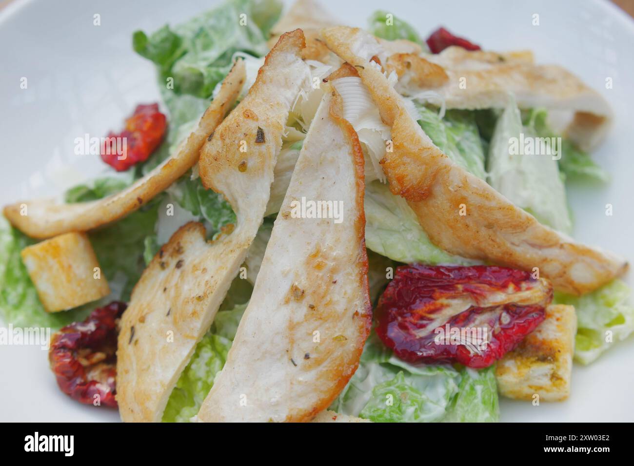A fresh and appetizing Caesar Salad made with grilled chicken and sundried tomatoes Stock Photo