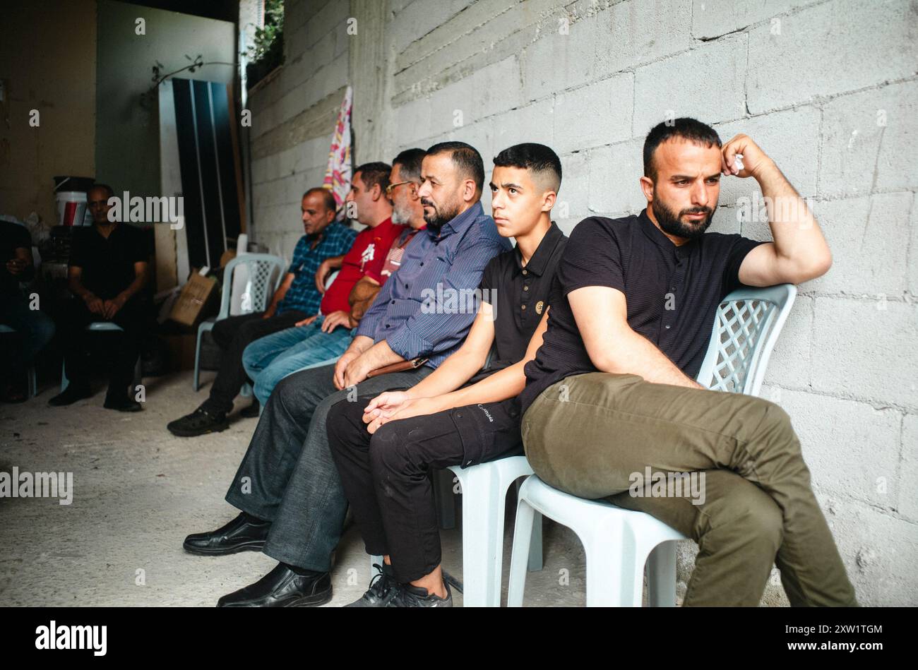 Qalqilya, West Bank. 16th Aug, 2024. Men await the autopsy report of Rashid Mahmoud Abdul Qader Sada so that the funeral process may begin. Relatives and neighbors hold a funeral for Rashid Mahmoud Abdul Qader Sada, 23, who was shot fatally during a settler raid in Jit the previous night. Jit, Qalqilya, West Bank, on August 16, 2024. (Photo by Brendan F. Rains/Sipa USA) Credit: Sipa USA/Alamy Live News Stock Photo