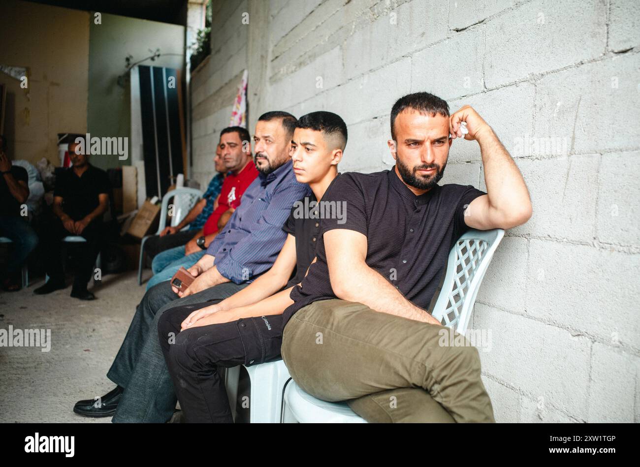 Qalqilya, West Bank. 16th Aug, 2024. Men await the autopsy report of Rashid Mahmoud Abdul Qader Sada so that the funeral process may begin. Relatives and neighbors hold a funeral for Rashid Mahmoud Abdul Qader Sada, 23, who was shot fatally during a settler raid in Jit the previous night. Jit, Qalqilya, West Bank, on August 16, 2024. (Photo by Brendan F. Rains/Sipa USA) Credit: Sipa USA/Alamy Live News Stock Photo