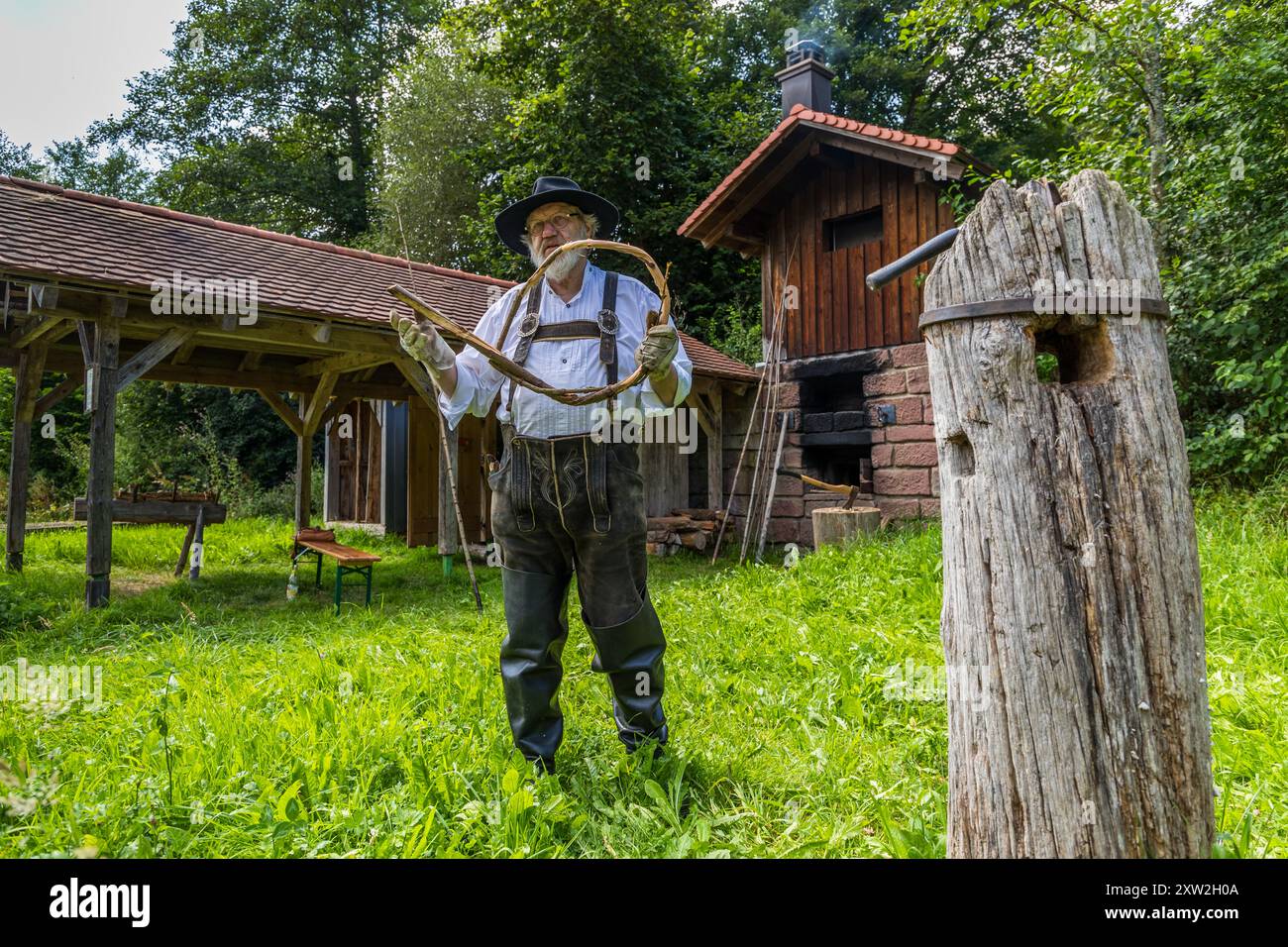 Raftsman Martin Spreng twisting wicker. The twisted material, known as wicker, is woven into rings and later used to bind the rafts. Several hundred wicker strands are often needed for a large raft. Altensteig, Baden-Württemberg, Germany Stock Photo