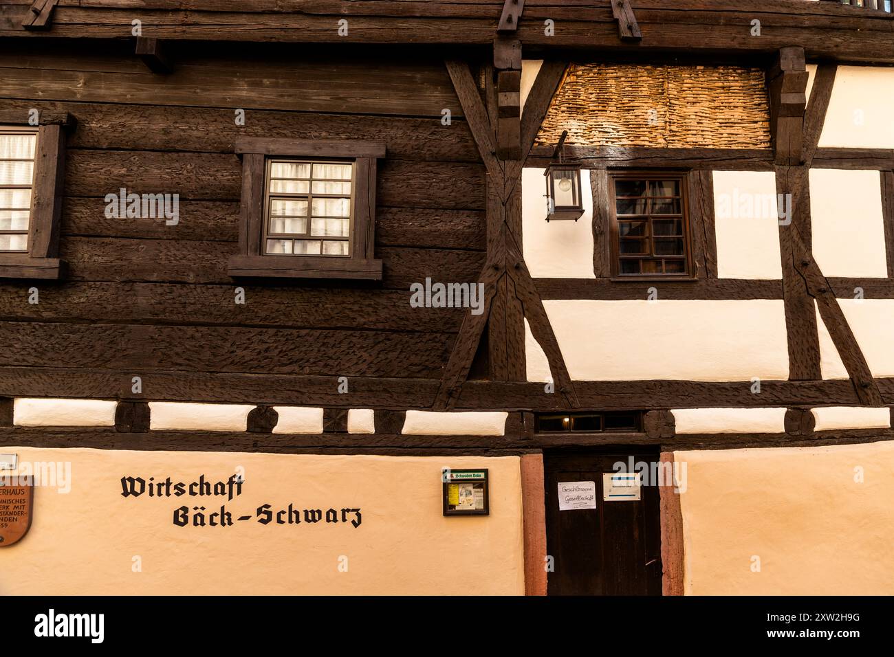 Half-timbered building with St. Andrew's cross. The half-timbered house, built in 1459, is home to the Bäck-Schwarz, one of the oldest inns still in operation in Germany and a landmark of half-timbered and old town culture in Altensteig, Black Forest. Wirtschaft Bäck-Schwarz (Bäck-Schwarz pub). Alte Steige, Altensteig, Baden-Württemberg, Germany Stock Photo