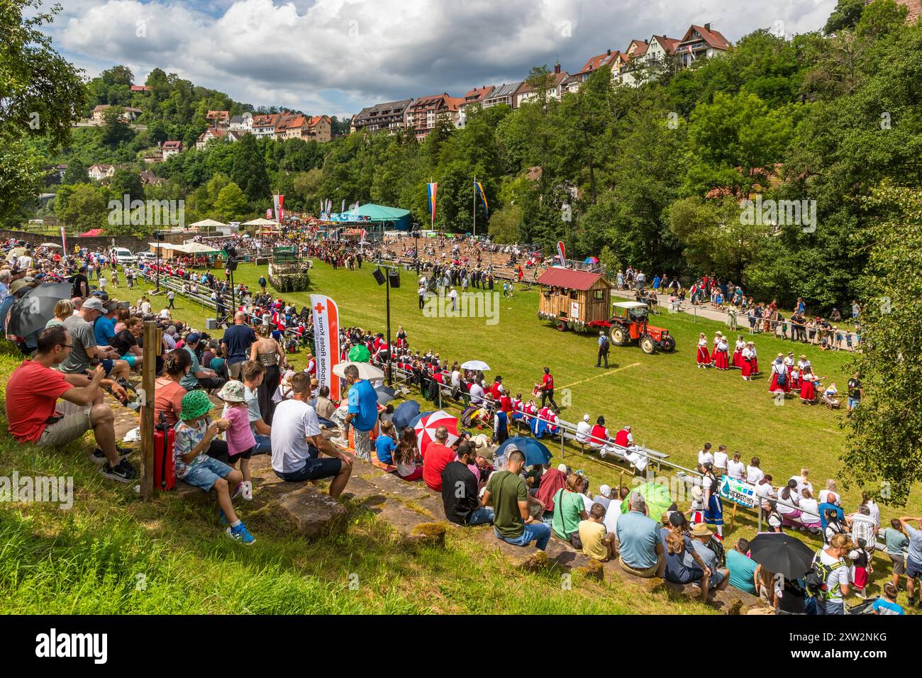 View of the Schäferlaufplatz below the village of Wildberg. Entry of the floats and traditional costume groups as well as shepherd groups and the public in the stands. The floats of the procession arrive at the festival site of the Schäferlauf 2024 in Wildberg, Baden-Württemberg, Germany Stock Photo