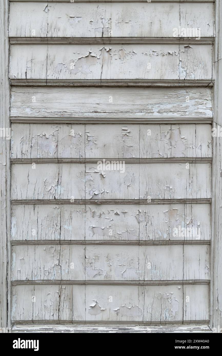 Wooden window shutters covered with white cracked paint. Backgrounds and textures. Stock Photo