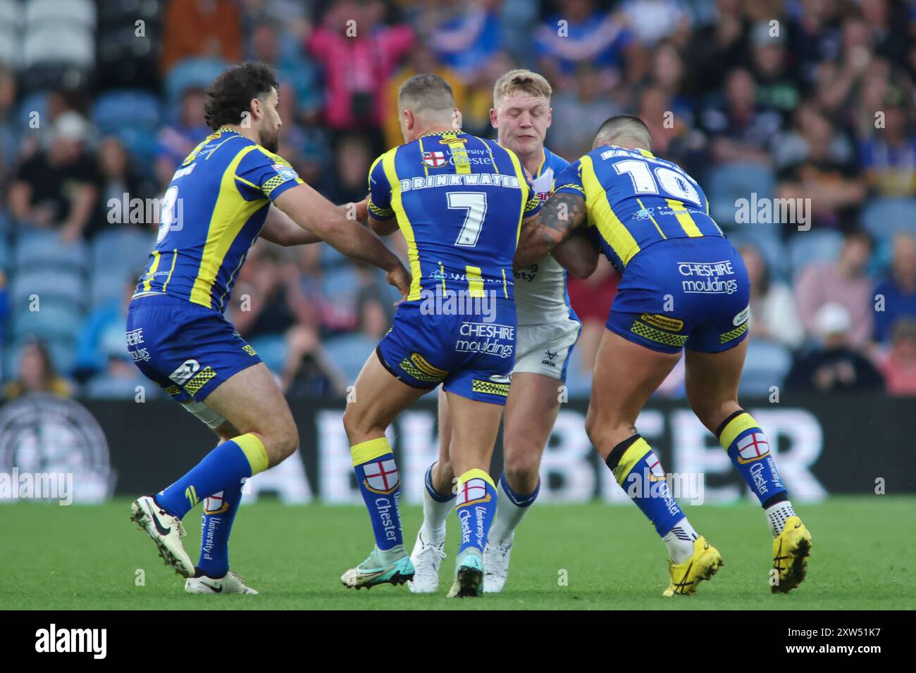 Leeds, UK. 17th Aug, 2024. Elland Road, Leeds, West Yorkshire, 17th August 2024. Betfred Super League - Magic Weekend Warrington Wolves vs Leeds Rhinos James McDonnell of Leeds Rhinos tackled by Josh Drinkwater and Paul Vaughan of Warrington Wolves Credit: Touchlinepics/Alamy Live News Stock Photo