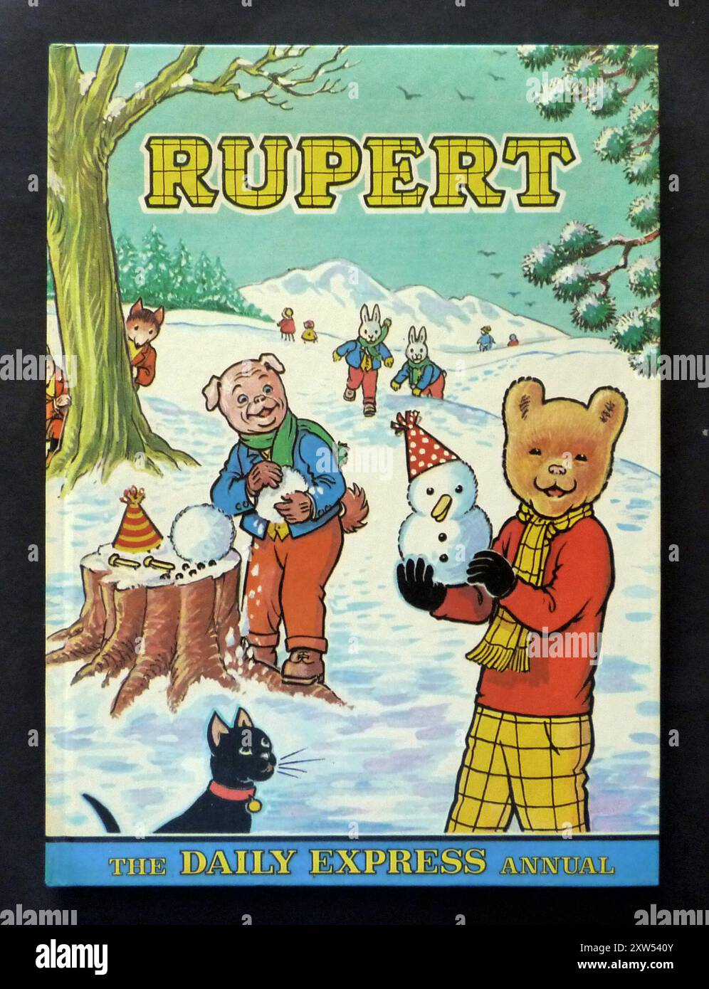 A vintage children’s ‘Rupert’ annual, published by The Daily Express Newspaper in 1974. The annual is based on the popular English children's comic strip character, Rupert Bear, who first appeared in the Daily Express in 1920. The colourful cover design depicts Rupert building snowmen with his friend Algy Pug. It also features Reggie and Rex Rabbit, and Freddy and Ferdie Fox. Stock Photo