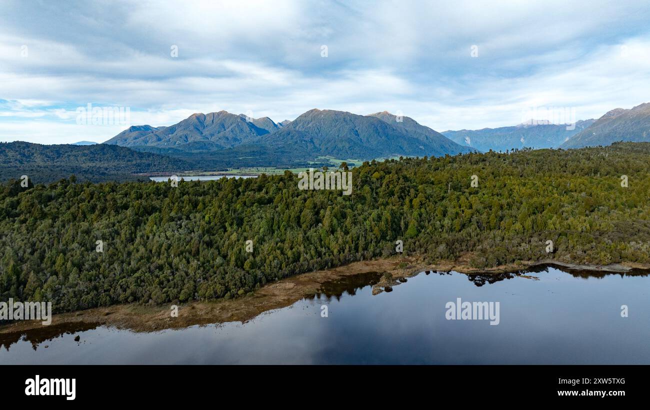 Remote Kapitea Reservoir reflections surrounded by mountain ranges ...