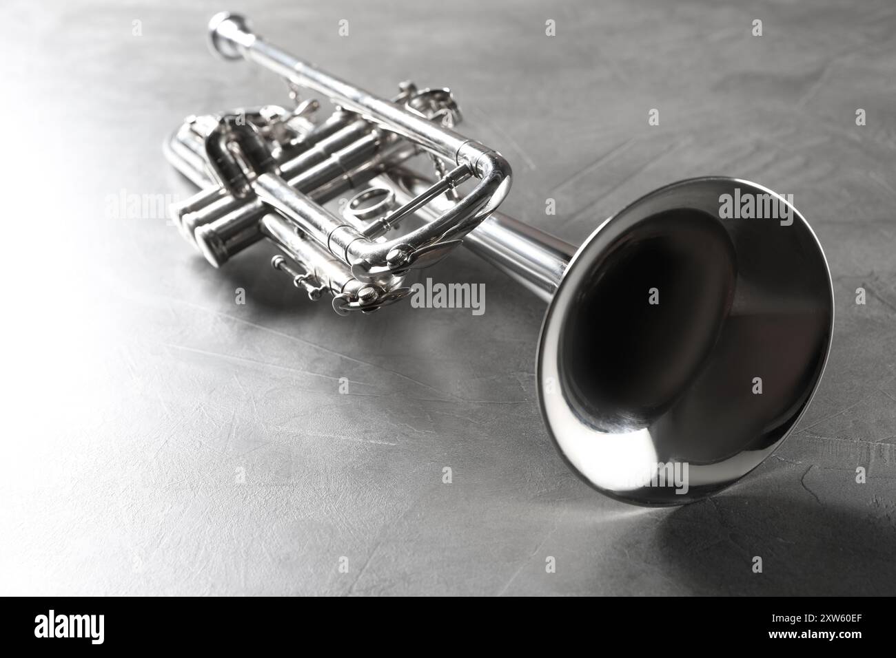 Shiny Instrument Shiny trumpet on grey textured table. Wind musical instrument Stock ...