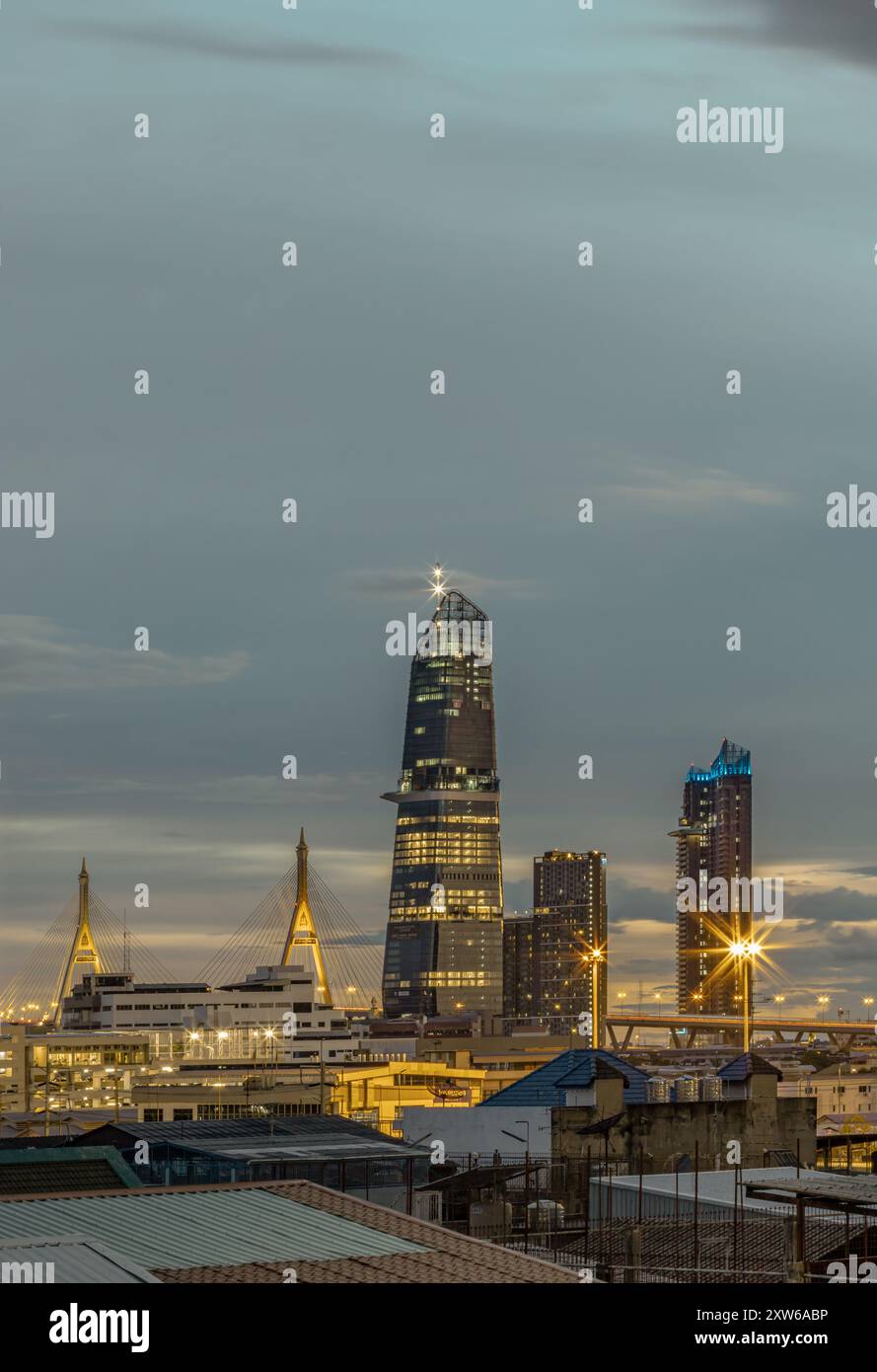 Bangkok, Thailand - Aug 14, 2024 - Night city view with KingBridge tower alongside the iconic landmark of Bhumibol Bridge. Stunning At Twilight skylin Stock Photo