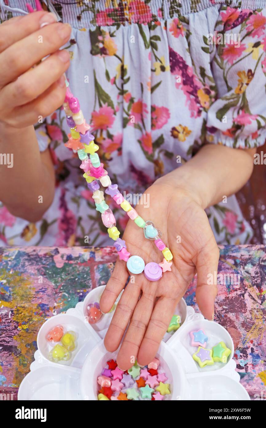Woman just Finished Making her Pastel Color DIY Beaded Necklace Workshop Stock Photo