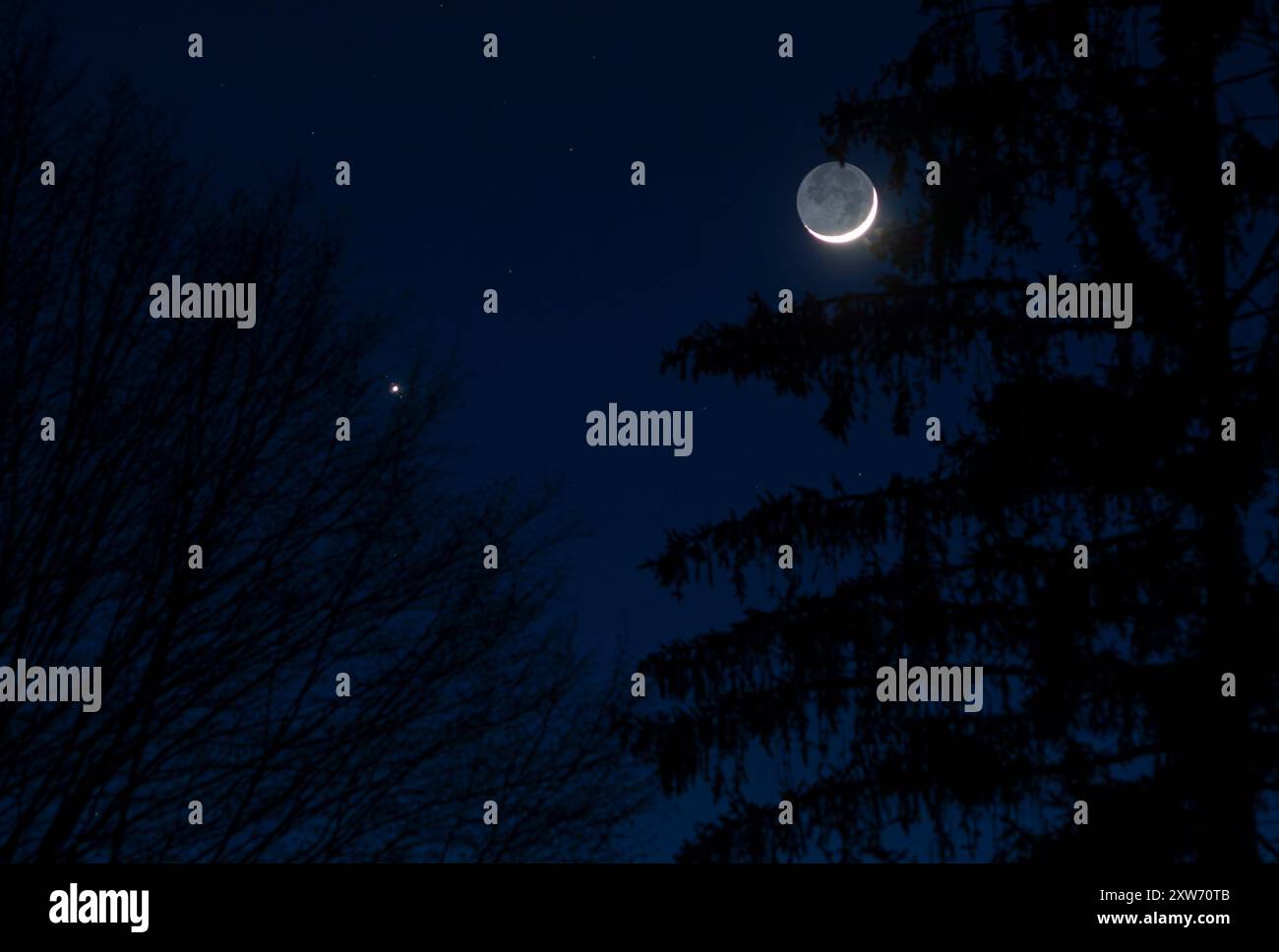Earthshine and Jupiter in the dusk Stock Photo