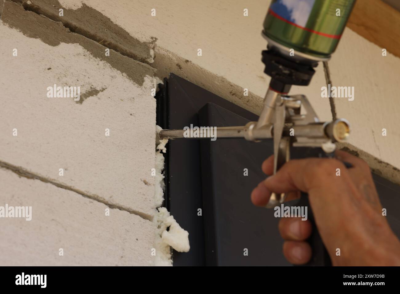 Repairman with polyurethane foam insulating new door at home, closeup ...