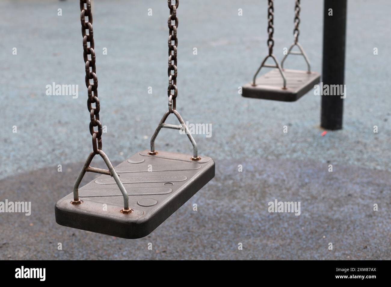 child's swings in an empty playpark Stock Photo - Alamy