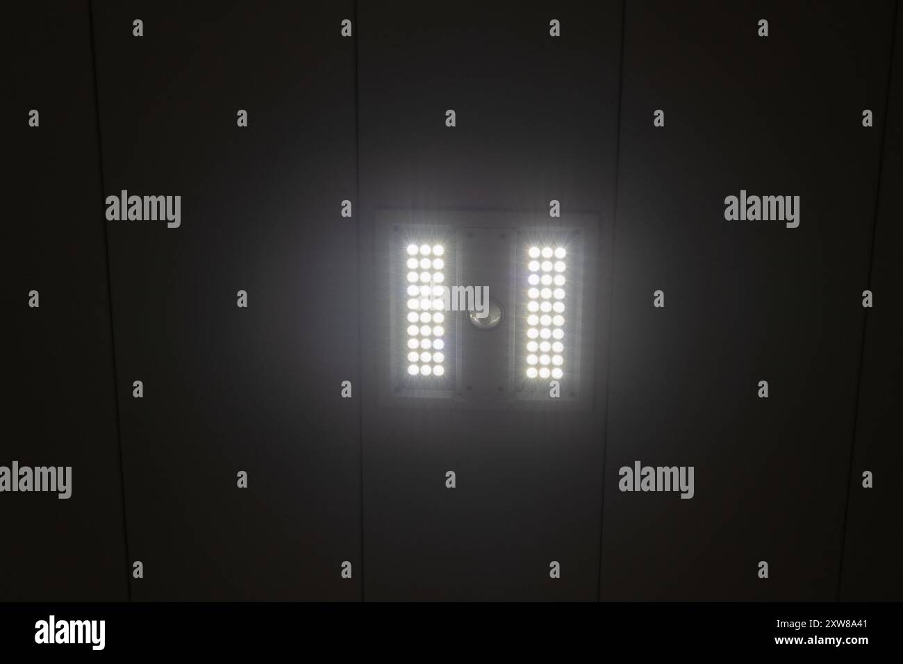 Overhead LED panel lights illuminate a dark room - sleek, modern design. Taken in Toronto, Canada. - Stock Image