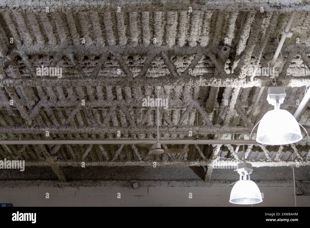 Industrial-style interior with hanging metal pendant lights - exposed ceiling beams and ductwork. Taken in Toronto, Canada. - Stock Image