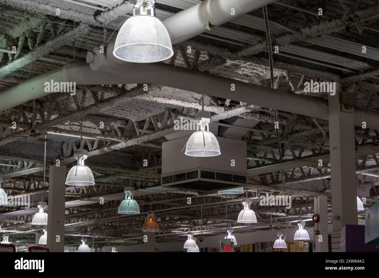 Industrial-style interior with hanging metal pendant lights - exposed ceiling beams and ductwork. Taken in Toronto, Canada. - Stock Image