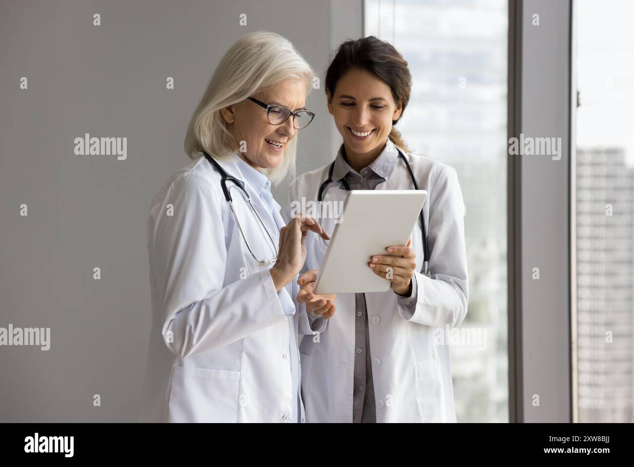 Doctors using tablet, review e-health application, think on treatment plan Stock Photo