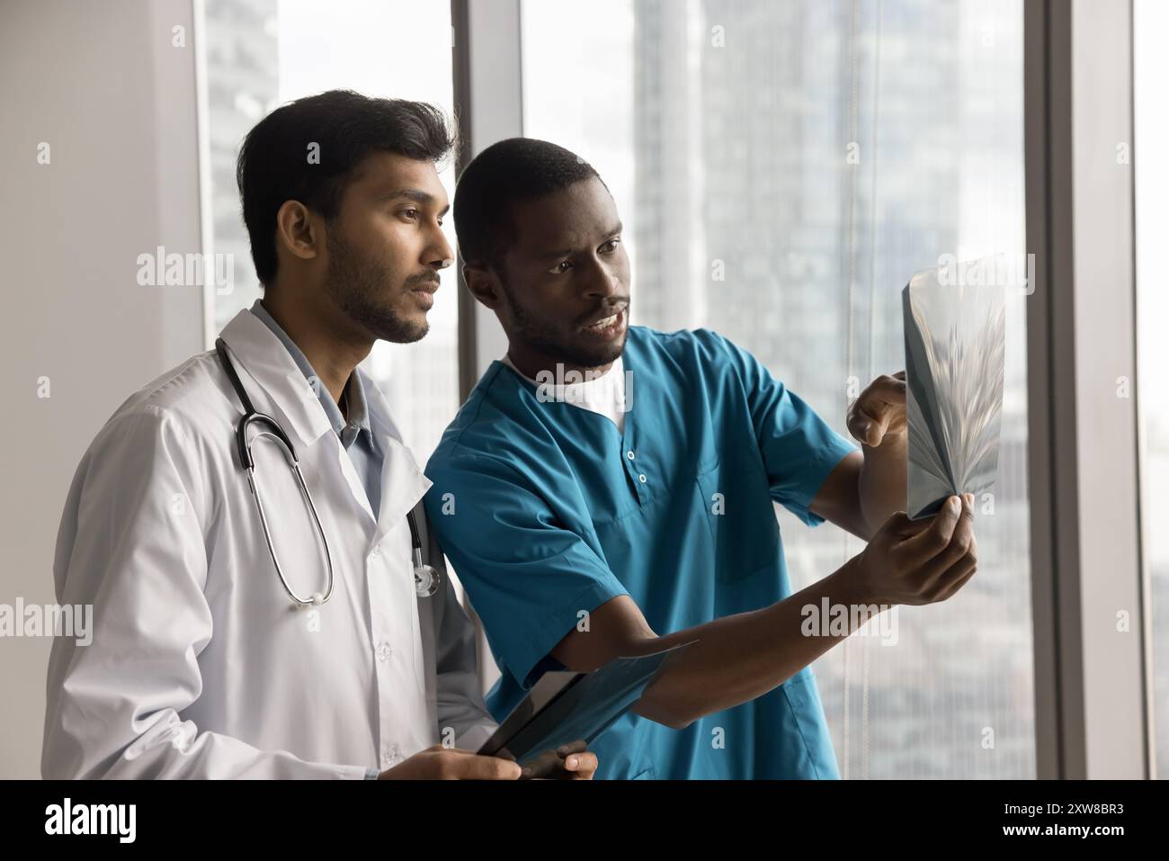 Two multiethnic male doctors examining X-ray images Stock Photo - Alamy