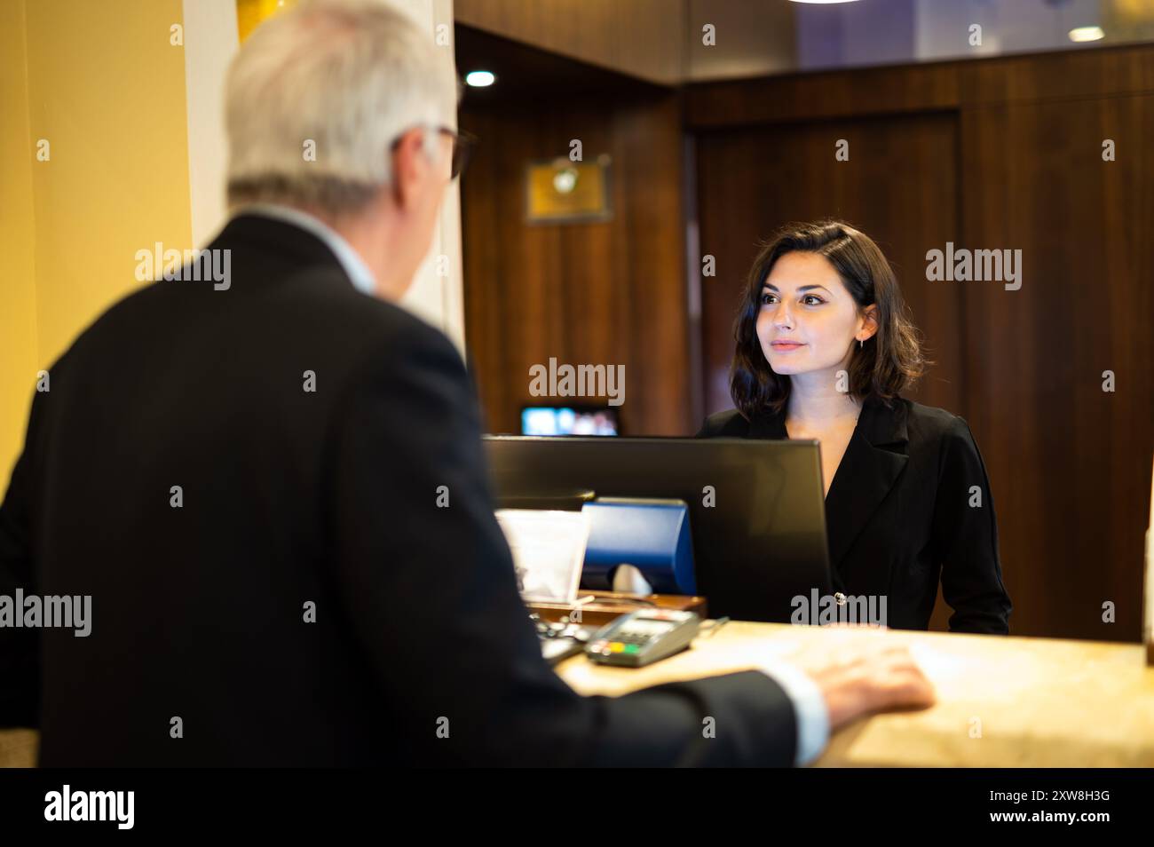 Customer checking in at a hotel reception stock photo alamy