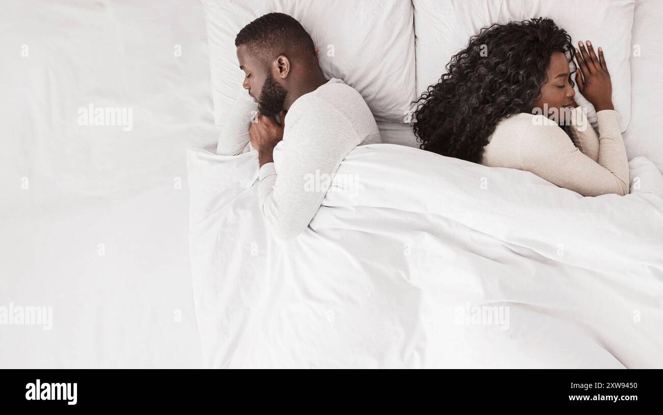 Black couple sleeping in bed back to back, top view Stock Photo - Alamy