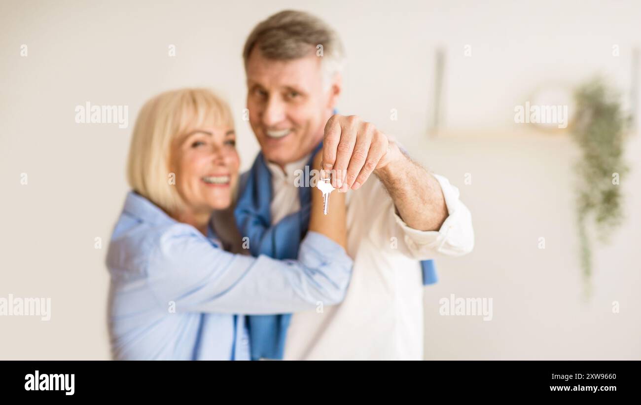 Senior couple moving into new home, man showing keys Stock Photo - Alamy