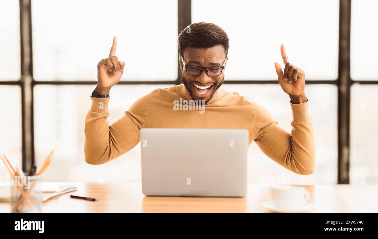 Ecstatic afro guy found new good idea Stock Photo