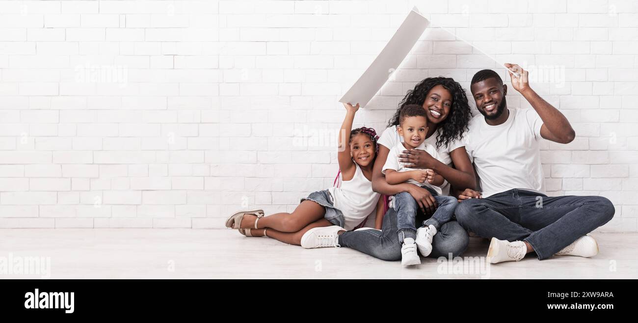 Happy African American Family Sitting On Floor Under Symbolic Roof ...