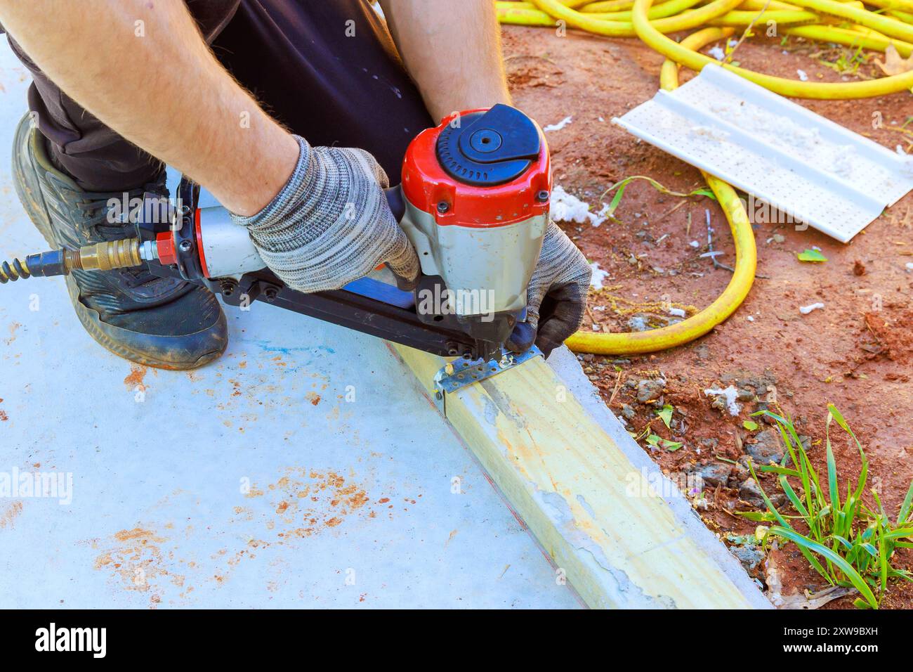 Nailing wooden beams to concrete with an air pneumatic hammer during ...