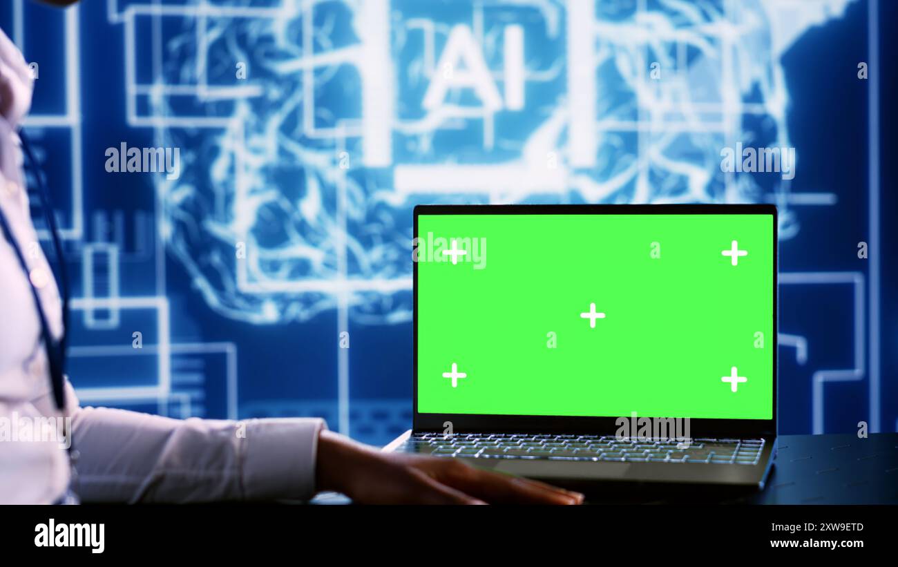 IT executive updating AI systems using green screen laptop, writing intricate binary code scripts. Technical support consultant using programming to upgrade artificial intelligence simulation model Stock Photo