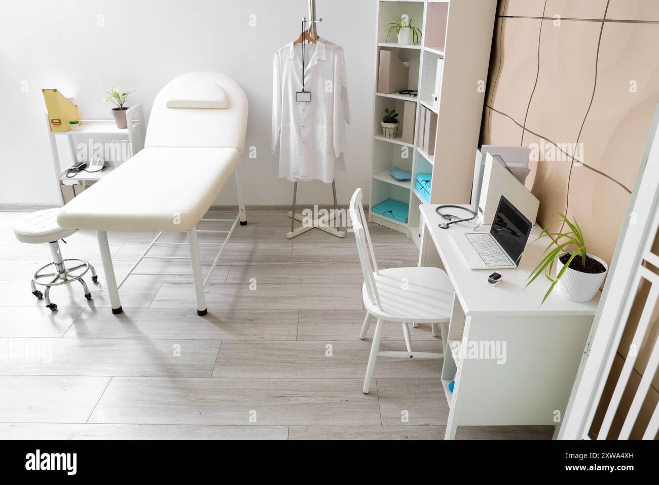 Interior of medical office with couch, shelf units and doctor's ...