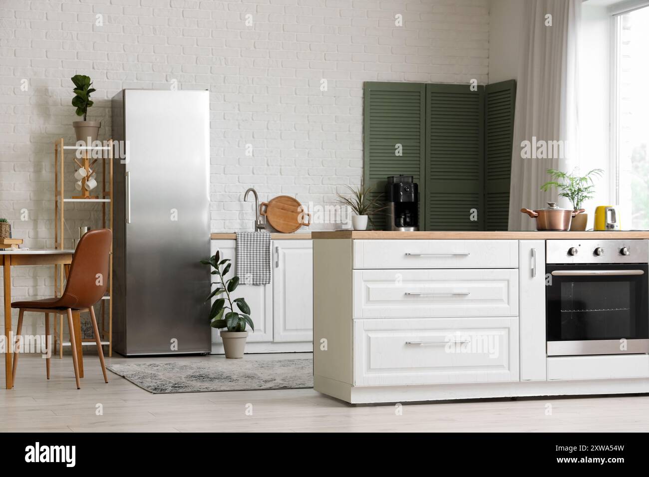 Interior of modern stylish kitchen with fridge, dining table and ...