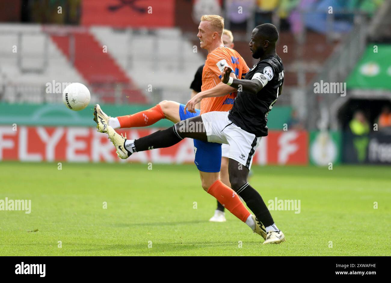 Hamburg, Germany. 18th Aug, 2024. Football: DFB Cup, FC Teutonia 05 Ottensen - SV Darmstadt 98, 1st round, Millerntor Stadium. Darmstadt's Isac Alexi Sivert Lidberg (l) in a duel against Marcus Coffie from FC Teutonia 05 Ottensen. Credit: Michael Schwartz/dpa - IMPORTANT NOTE: In accordance with the regulations of the DFL German Football League and the DFB German Football Association, it is prohibited to utilize or have utilized photographs taken in the stadium and/or of the match in the form of sequential images and/or video-like photo series./dpa/Alamy Live News Stock Photo