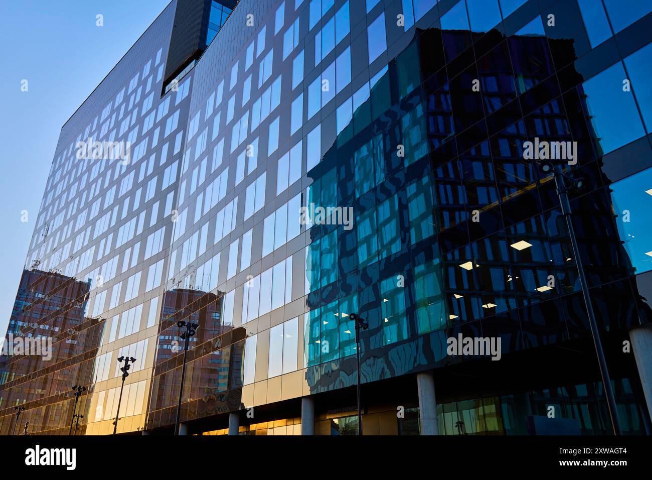 Modern glass office building reflecting city skyline in windows at ...