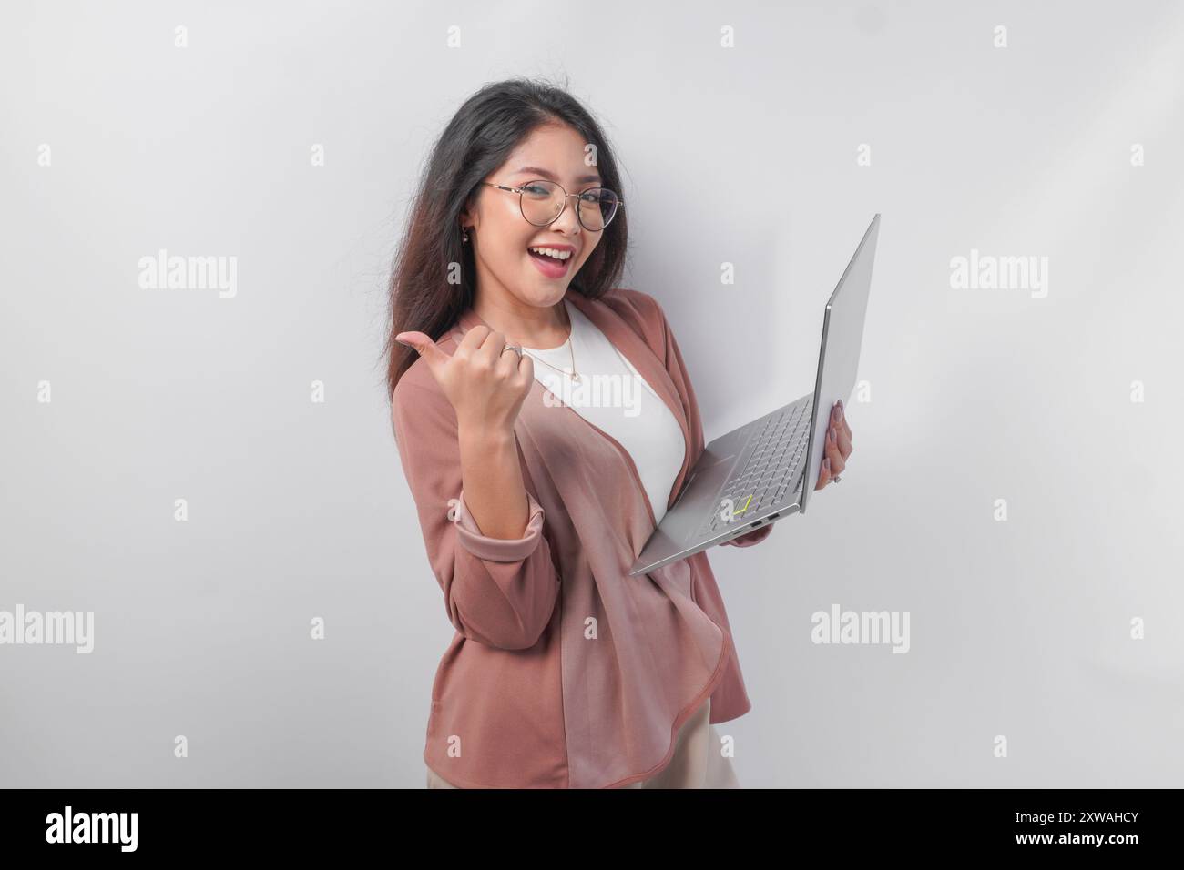 Cheerful young Asian business woman showing thumbs up and holding ...