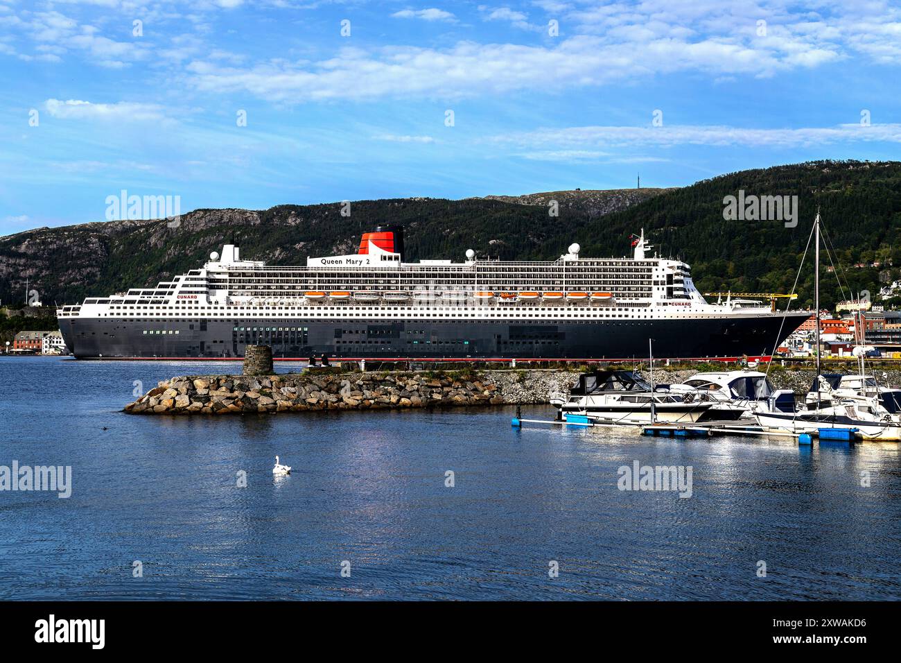 Cruise ship Queen Mary 2 at Jekteviksterminalen quay, in the port of Bergen, Norway. Kirkebukten with small pleasure crafts Stock Photo