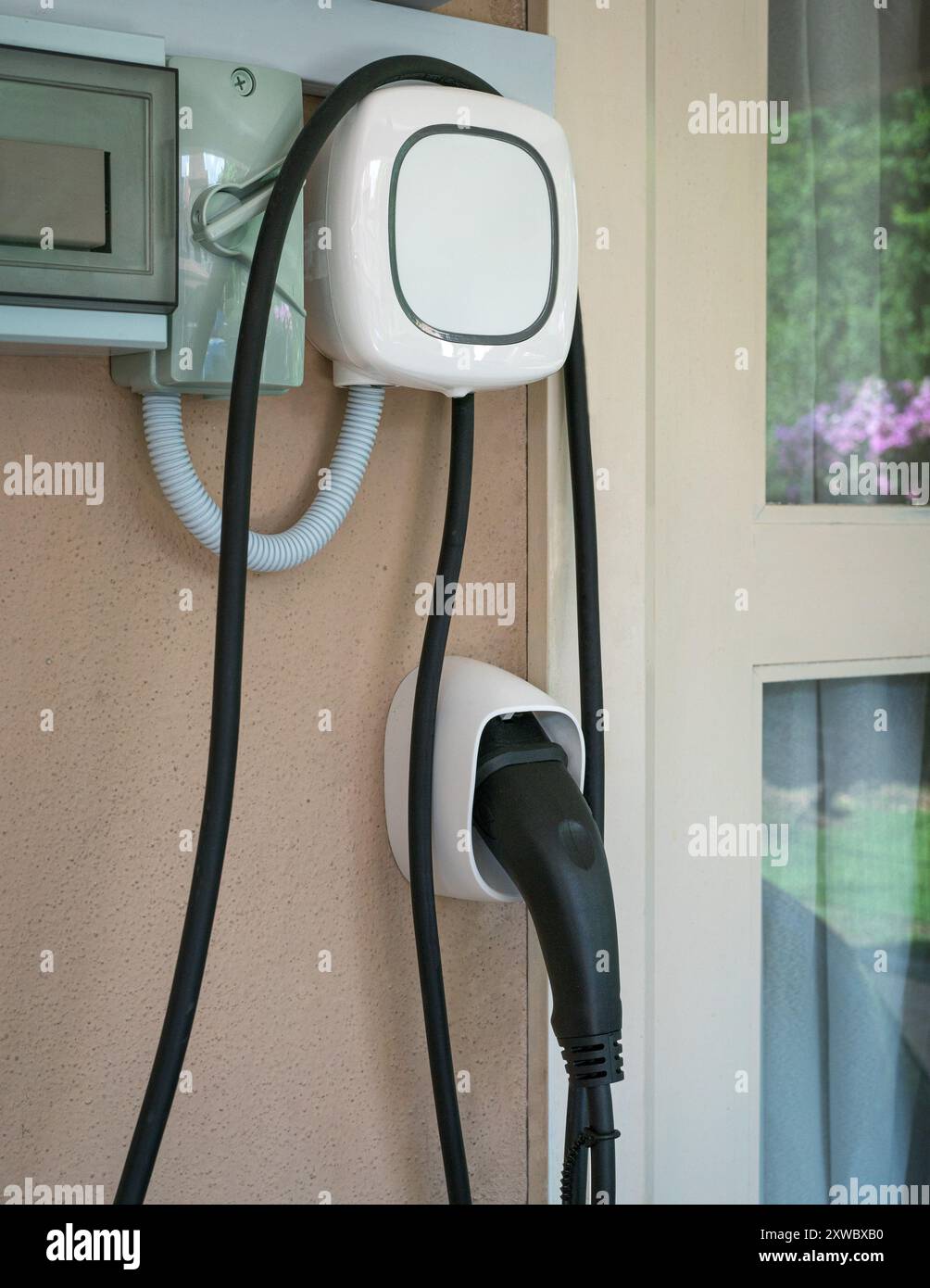 Wall charging station for electric car installed in a residential house. Stock Photo