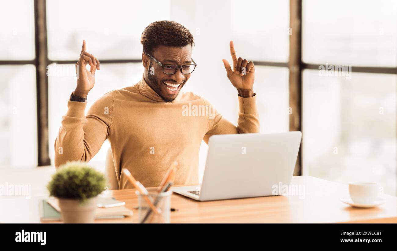 Ecstatic afro guy found new good idea Stock Photo