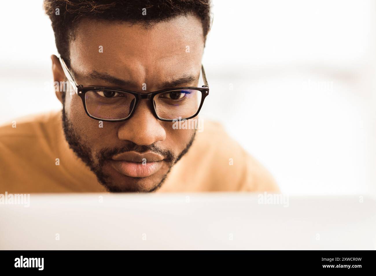 Headshot of afro man working on laptop Stock Photo