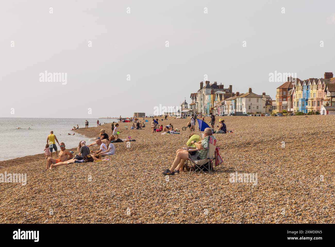 Tourists sunbathing and relaxing on Aldeburgh beach on a summer day. Aldeburgh, Suffolk. UK Stock Photo