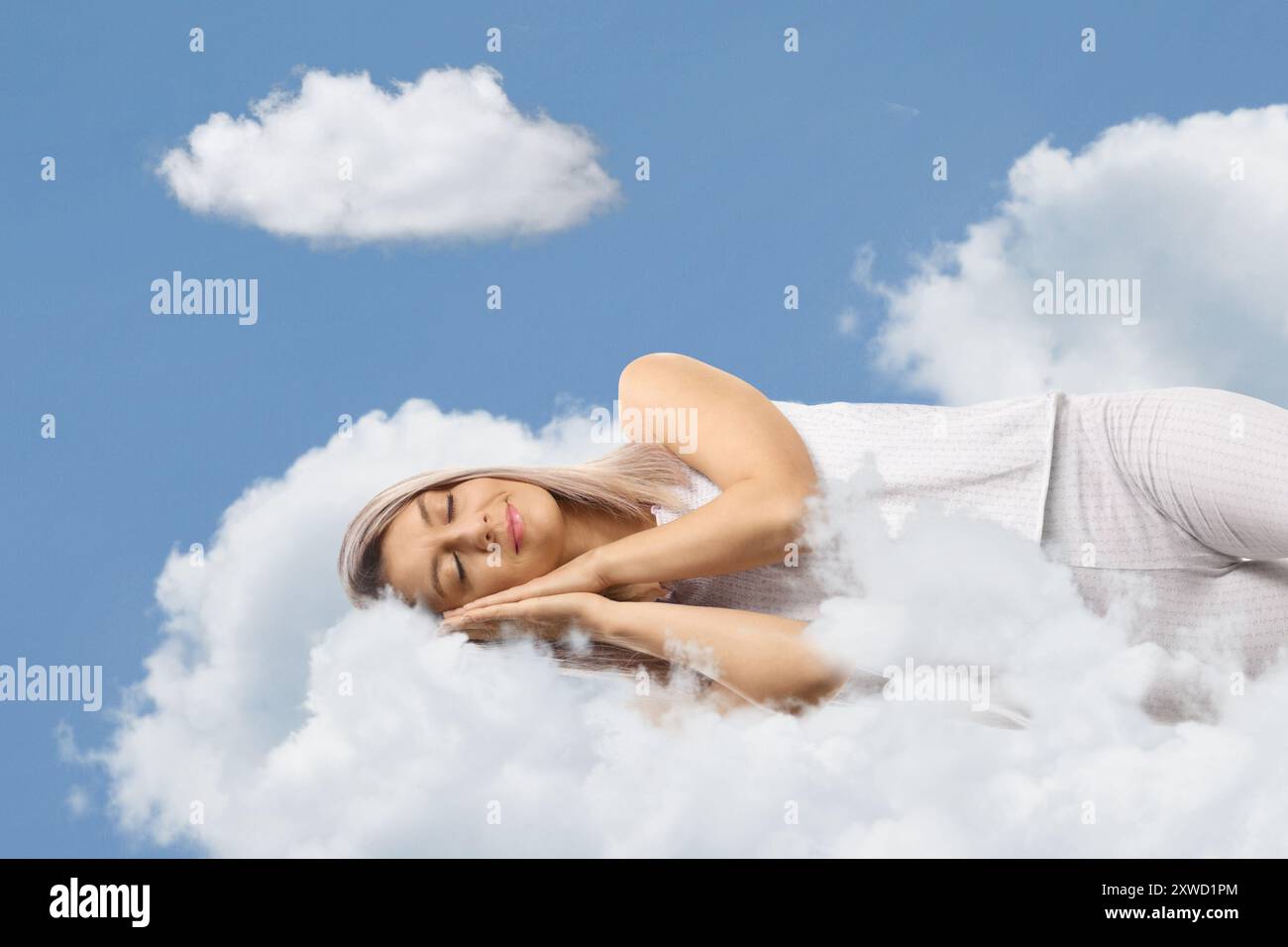 Young woman sleeping on a cloud Stock Photo