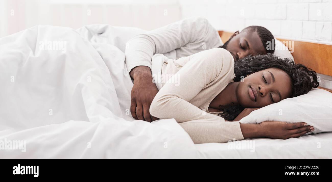 Afro couple sleeping together in comfortable bed at home Stock Photo ...