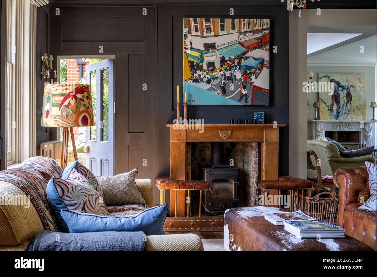 Floor lamp with modern art above wooden fireplace in Wimbledon home ...