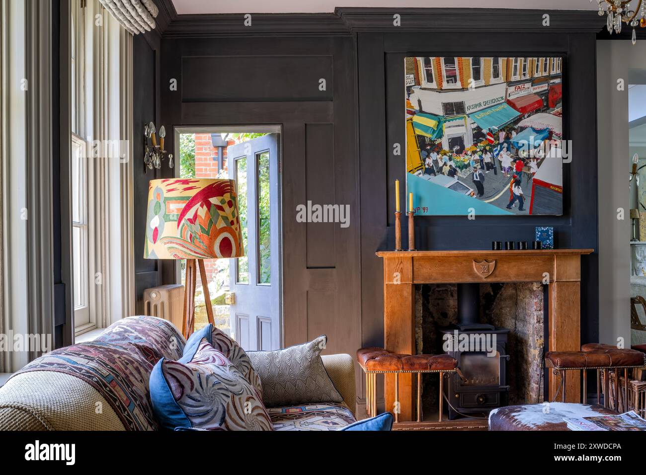 Floor lamp with modern art above wooden fireplace in Wimbledon home ...