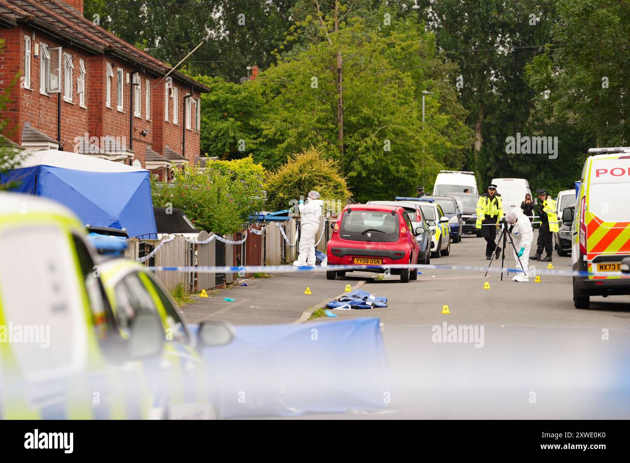 Forensic officers near a property in Barnard Road in Gorton, Manchester, where officers were called on Sunday evening to three people suffering serious stab wounds. A 43-year-old woman died at the scene, and a 17-year-old girl and 64-year-old man are being treated in hospital. A 22-year-old man has been arrested on suspicion of murder. Picture date: Monday August 19, 2024. Stock Photo