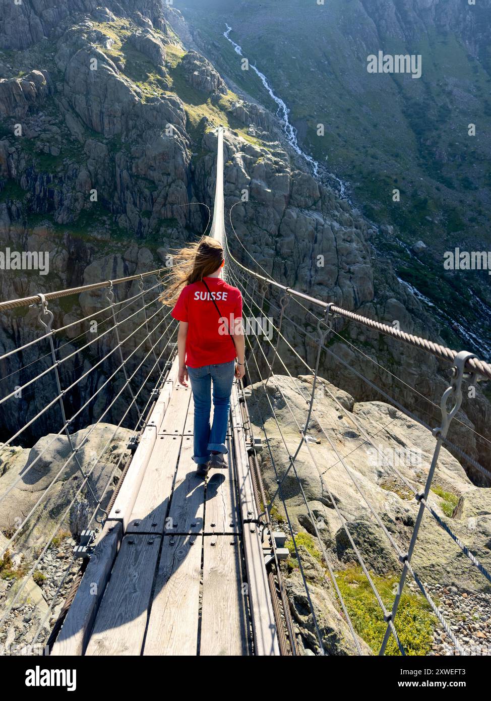 Young woman crossing the chasm on the rope bridge Stock Photo - Alamy