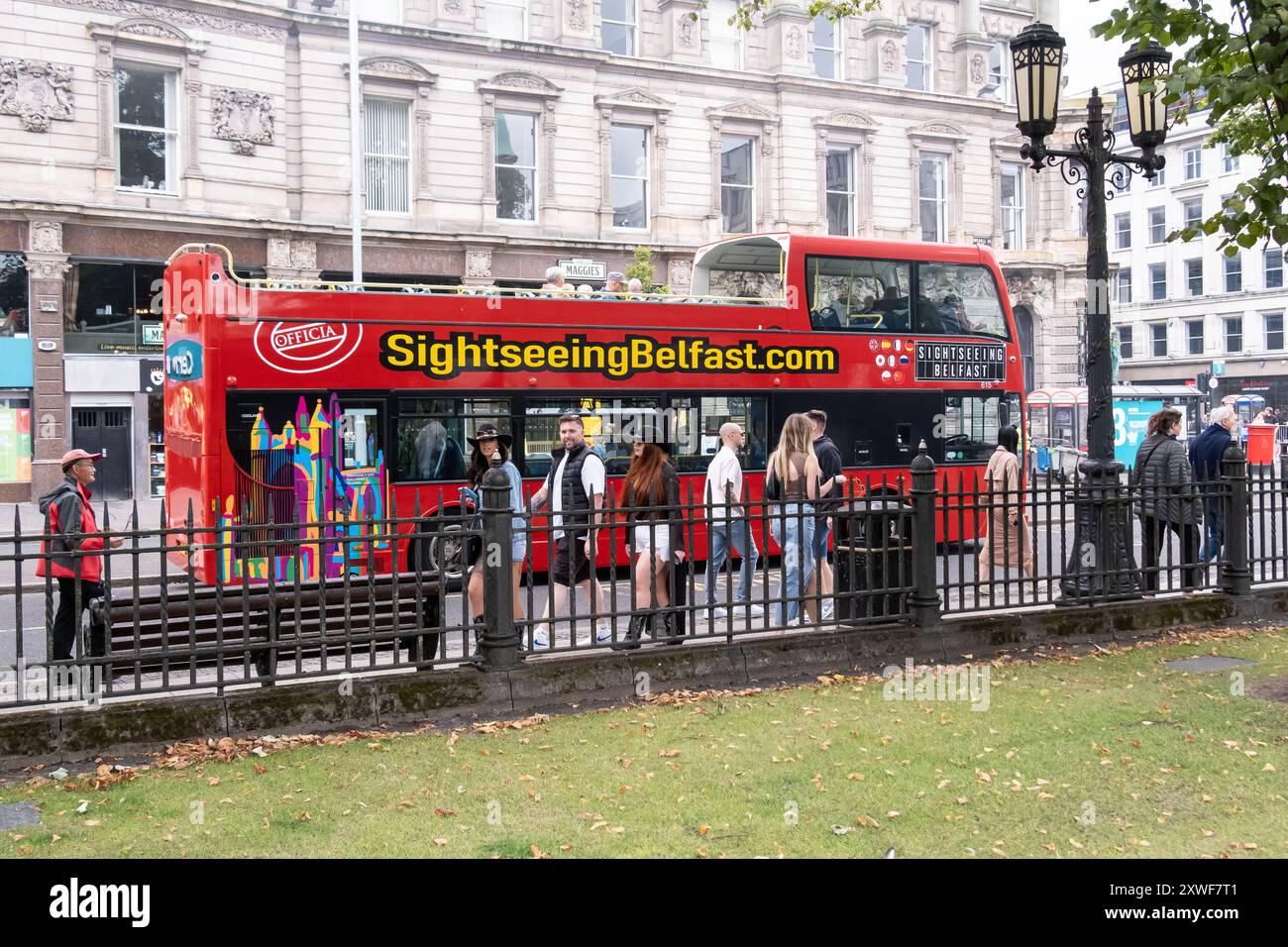 Belfast, UK - August 17th, 2024: city centre red open top sightseeing bus running tourist excursions. Stock Photo