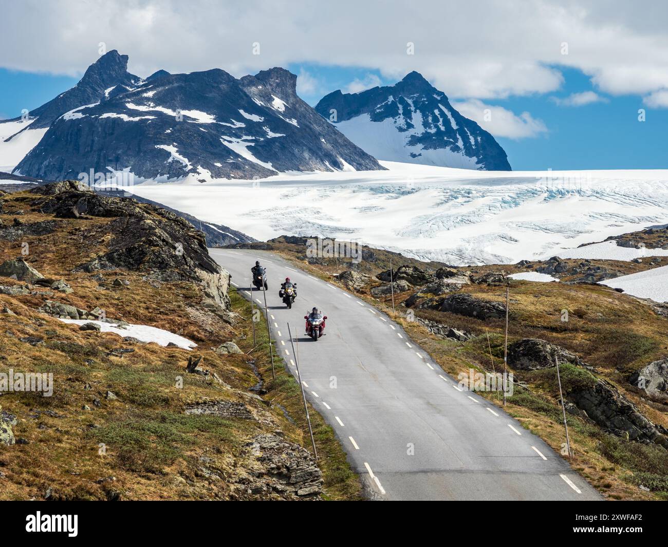 Group of motorcyclists on mountain crossing Sognefjellsvegen, view towards glacier,  mountain pass over the Sognefjellet,  Norway Stock Photo
