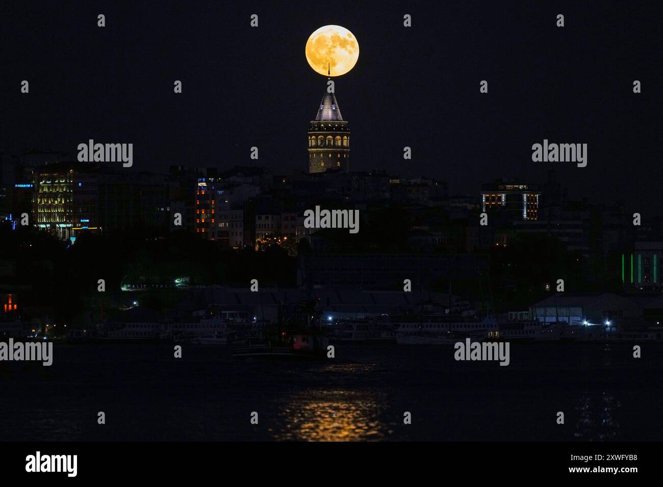A supermoon rises behind the Galata Tower in Istanbul, Turkey, Monday ...