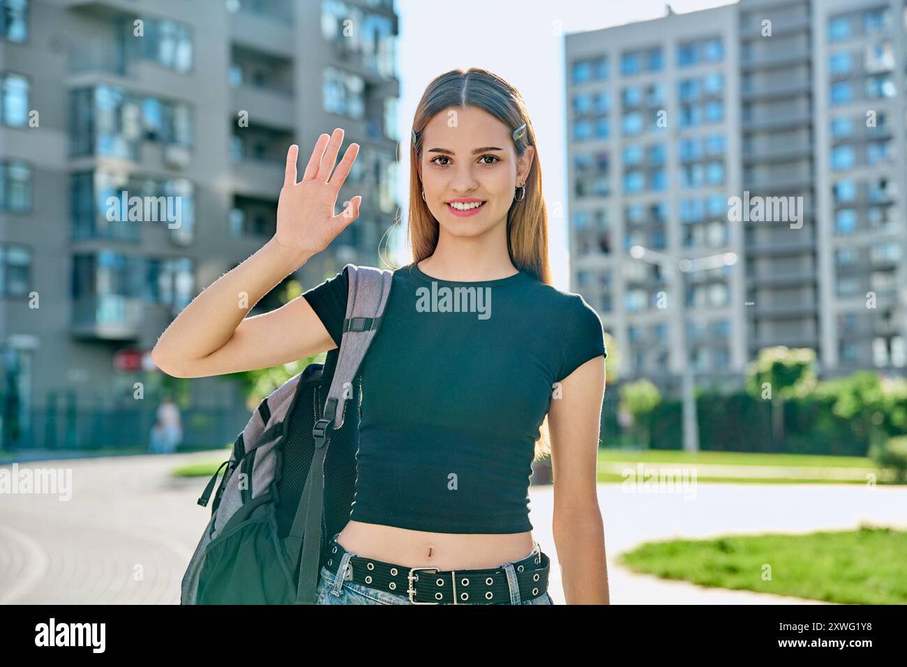 College student girl with backpack waving hand to camera, outdoor Stock ...