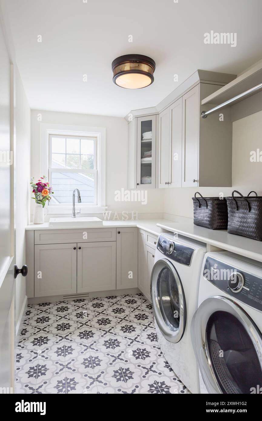 Laundry room with gray cabinets and floor tile with geometric design ...